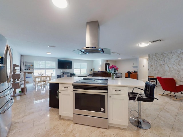 kitchen featuring island exhaust hood, stainless steel appliances, light countertops, open floor plan, and white cabinets