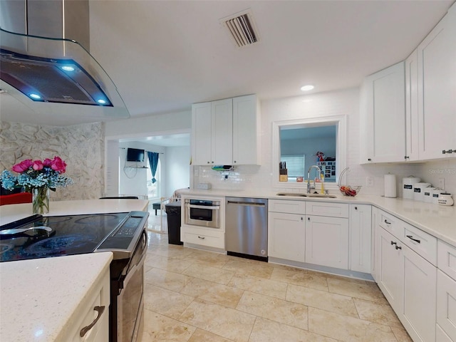 kitchen featuring tasteful backsplash, visible vents, stainless steel appliances, white cabinetry, and a sink