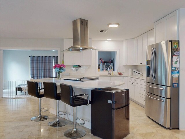 kitchen featuring light countertops, island exhaust hood, white cabinetry, and stainless steel fridge with ice dispenser