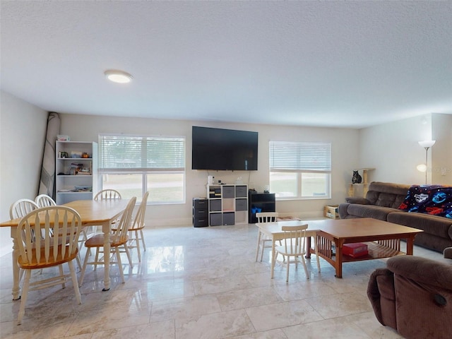 living room featuring a textured ceiling and baseboards