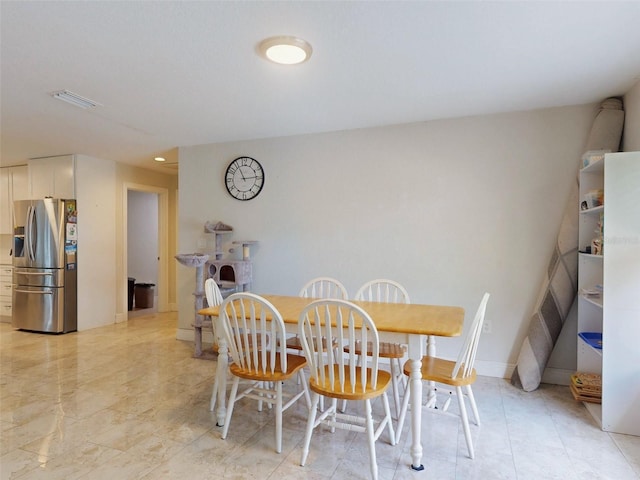 dining space featuring baseboards and visible vents