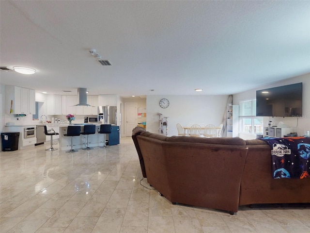 living area with visible vents and a textured ceiling