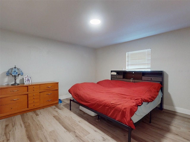 bedroom featuring light wood-style floors and baseboards