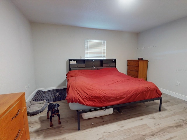 bedroom featuring baseboards and light wood finished floors