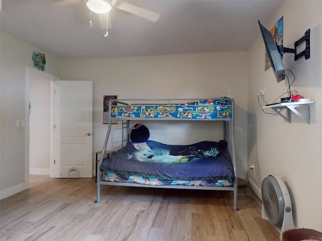 bedroom featuring light wood-style flooring, baseboards, and ceiling fan