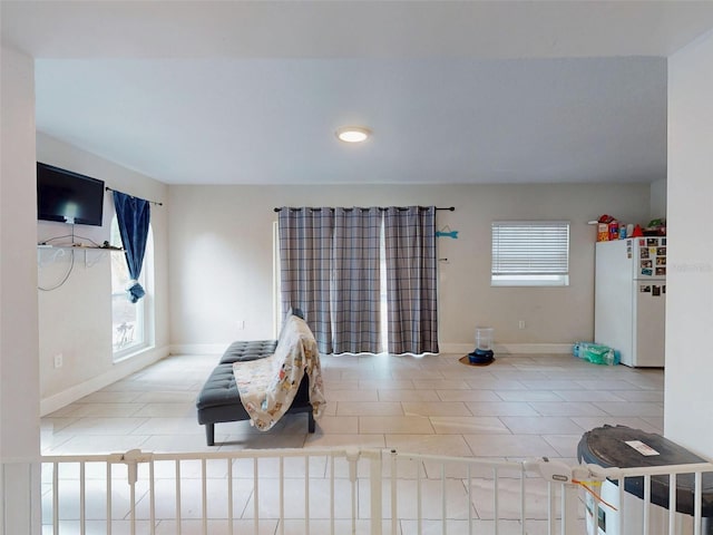 interior space featuring light tile patterned floors and baseboards