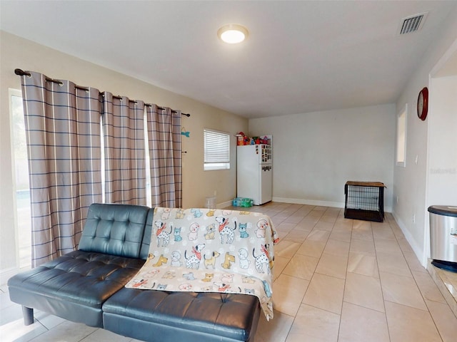 living room with tile patterned flooring, visible vents, and baseboards