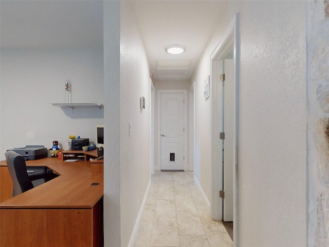 hall with baseboards and a textured wall