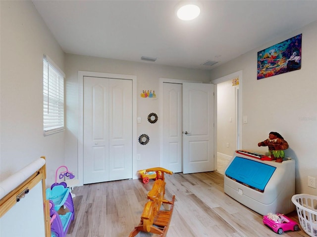 rec room with light wood finished floors and visible vents