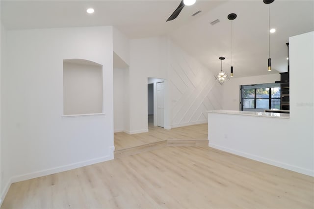 unfurnished living room with lofted ceiling, visible vents, light wood-style floors, ceiling fan, and baseboards