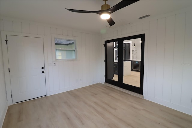 unfurnished room with visible vents, ceiling fan, light wood-style flooring, and baseboards