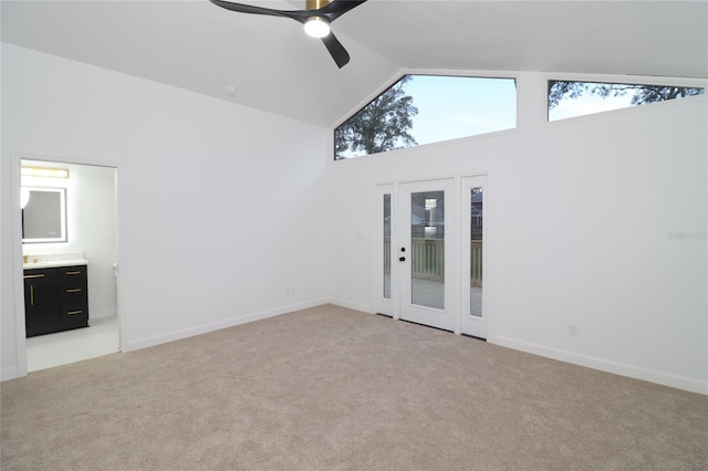 interior space with high vaulted ceiling, light colored carpet, ceiling fan, and baseboards