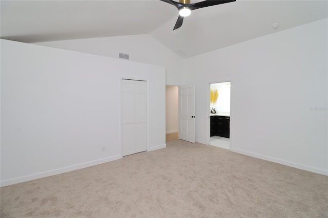 unfurnished bedroom with light colored carpet, visible vents, baseboards, vaulted ceiling, and a closet