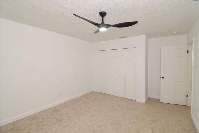 unfurnished bedroom with a closet, light colored carpet, visible vents, and baseboards