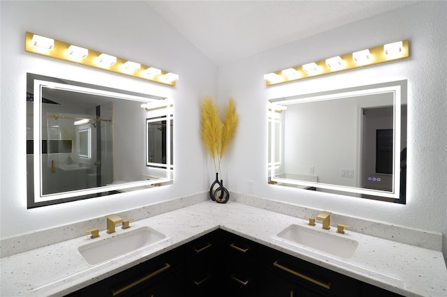 full bathroom with double vanity, a sink, and lofted ceiling