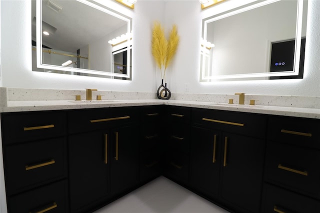 bathroom with visible vents, a sink, and double vanity