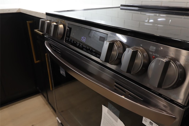 interior details with electric stove and dark cabinetry