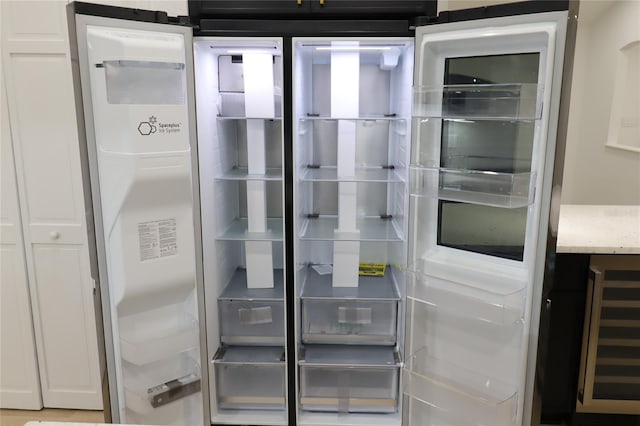 interior space with wine cooler and refrigerator with glass door