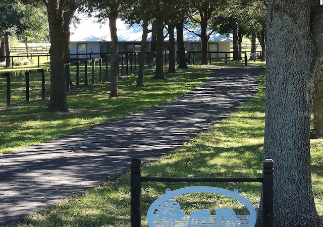 view of property's community with fence and a yard