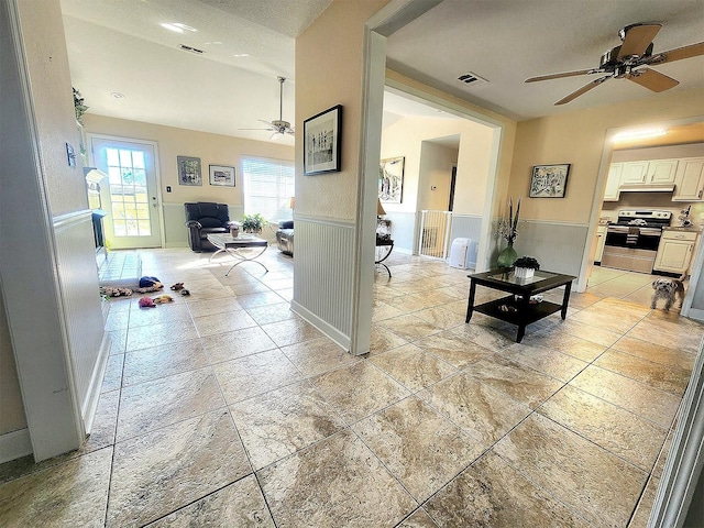 hall featuring a wainscoted wall and visible vents