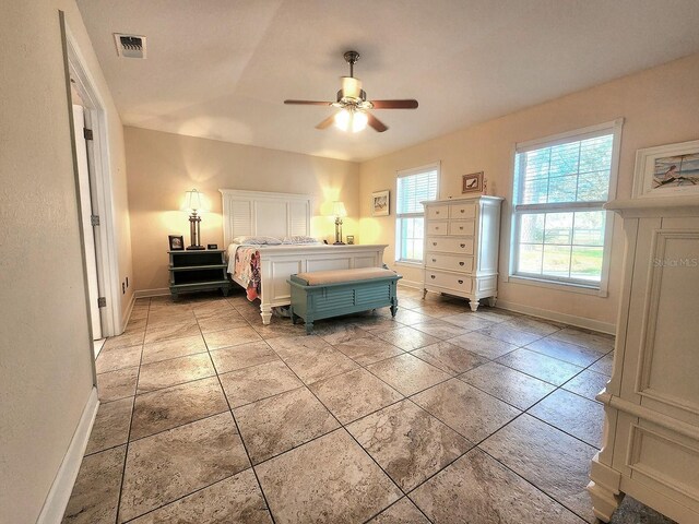 bedroom featuring a ceiling fan, visible vents, baseboards, and light tile patterned floors