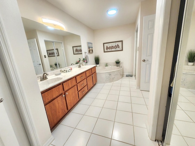 bathroom featuring a garden tub, a sink, and tile patterned floors