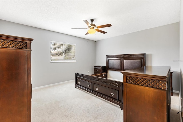 bedroom with baseboards, ceiling fan, a textured ceiling, and light colored carpet