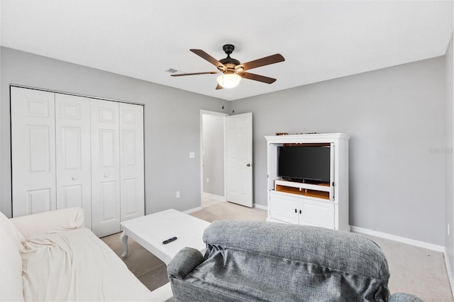 bedroom featuring ceiling fan, light colored carpet, visible vents, baseboards, and a closet