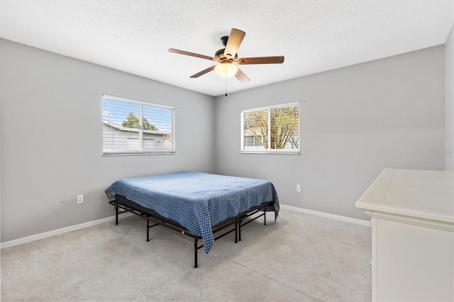 bedroom featuring baseboards, a textured ceiling, and light colored carpet