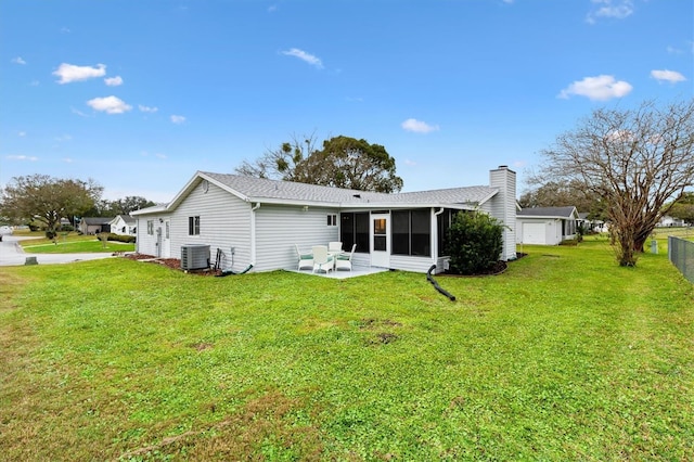 back of house featuring central AC unit, a chimney, fence, a yard, and a patio area