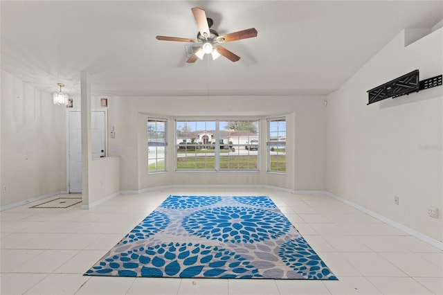 interior space with vaulted ceiling, ceiling fan, tile patterned flooring, and baseboards