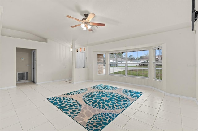 interior space with baseboards, visible vents, a ceiling fan, tile patterned floors, and vaulted ceiling