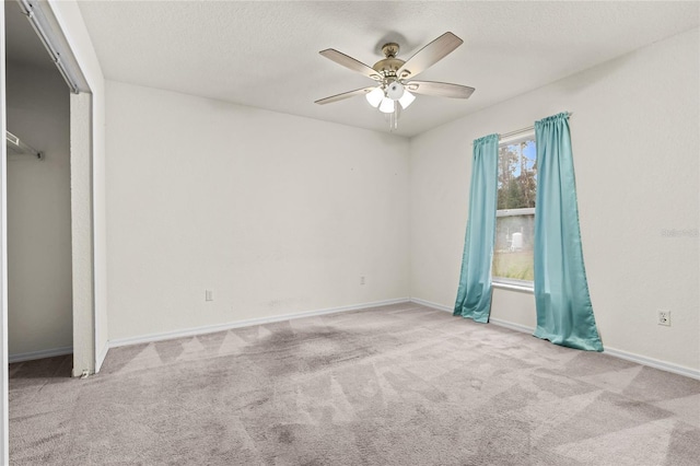 unfurnished bedroom with baseboards, carpet, a ceiling fan, and a textured ceiling