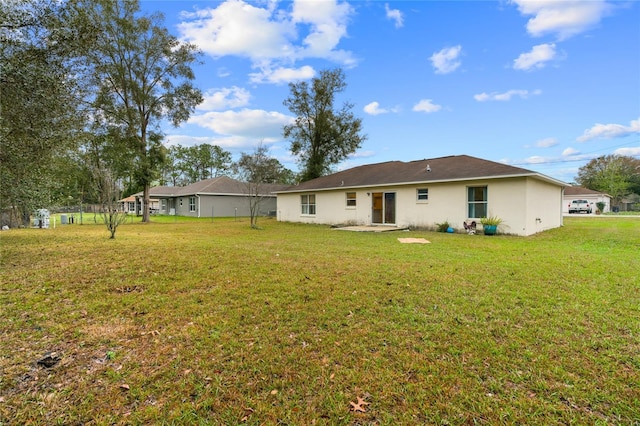 back of property featuring a patio and a yard