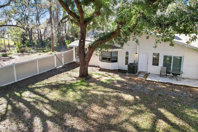 rear view of house featuring a yard, a fenced backyard, cooling unit, and a patio