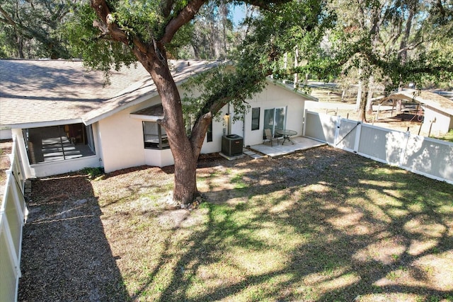 back of house featuring cooling unit, fence, roof with shingles, stucco siding, and a patio area