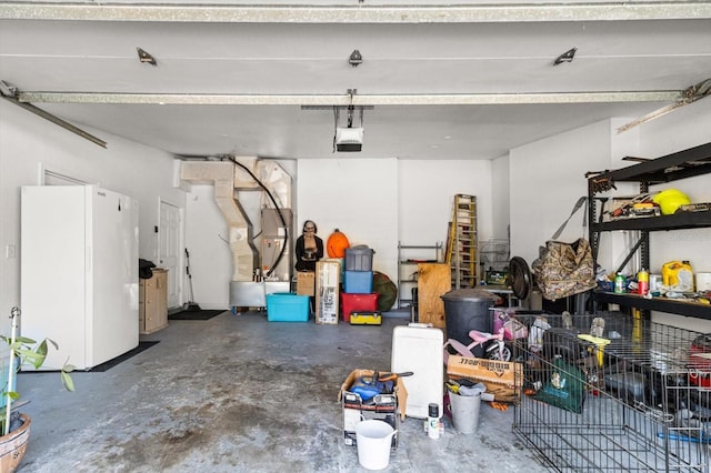 garage featuring freestanding refrigerator and a garage door opener