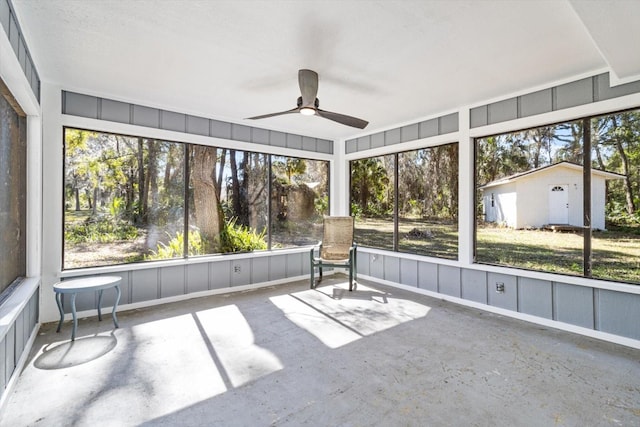 unfurnished sunroom featuring a ceiling fan