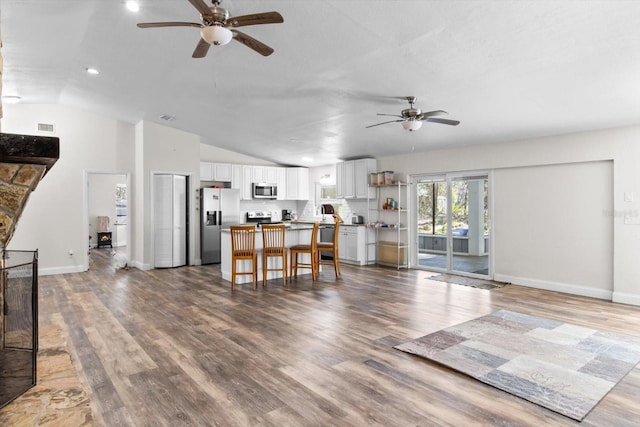 living area featuring visible vents, ceiling fan, and wood finished floors