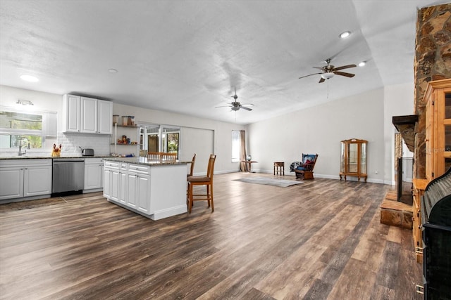 kitchen with a healthy amount of sunlight, white cabinetry, open floor plan, and dishwasher