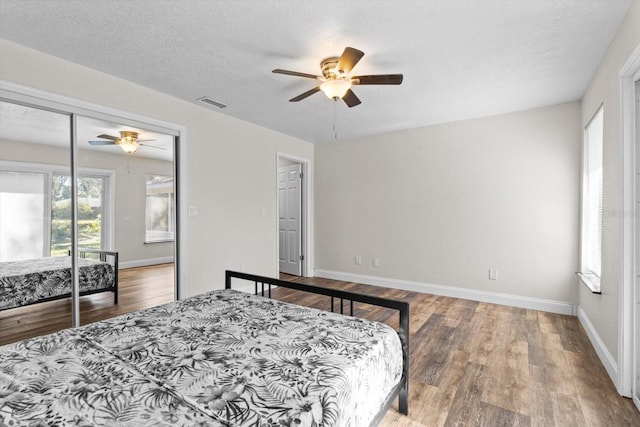 bedroom featuring baseboards, visible vents, and wood finished floors