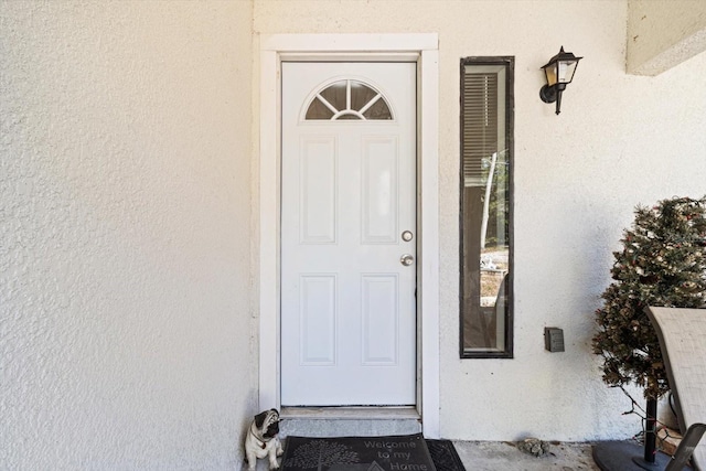 property entrance with stucco siding