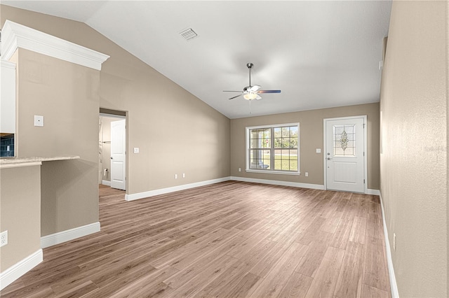 unfurnished living room with a ceiling fan, visible vents, vaulted ceiling, and wood finished floors