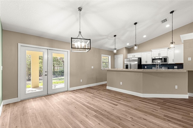 kitchen featuring pendant lighting, visible vents, appliances with stainless steel finishes, white cabinetry, and light wood-type flooring