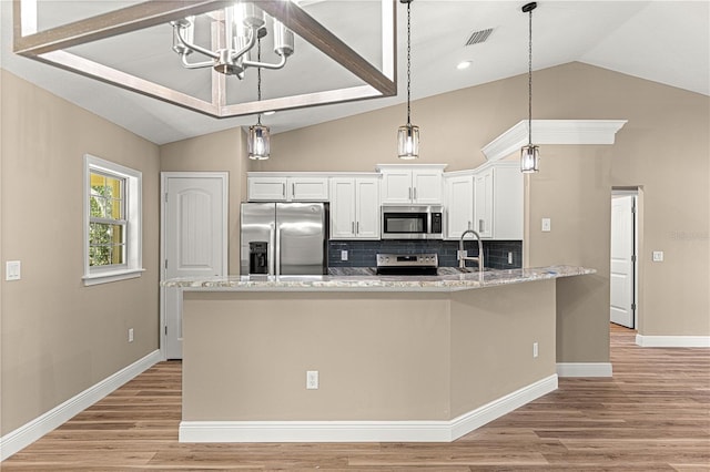 kitchen with appliances with stainless steel finishes, white cabinets, a center island with sink, and light stone countertops