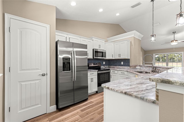 kitchen with light stone counters, pendant lighting, stainless steel appliances, white cabinetry, and a peninsula