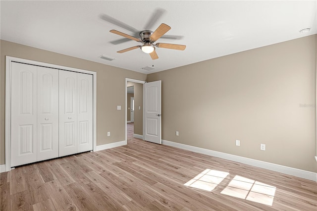 unfurnished bedroom featuring a ceiling fan, visible vents, baseboards, a closet, and light wood finished floors