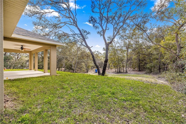 view of yard featuring ceiling fan and a patio