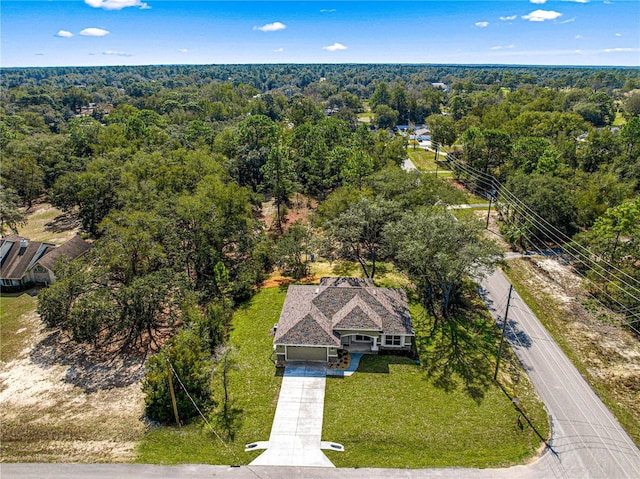 drone / aerial view featuring a wooded view