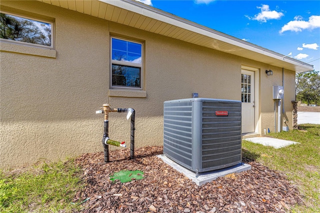 exterior details with central AC unit and stucco siding